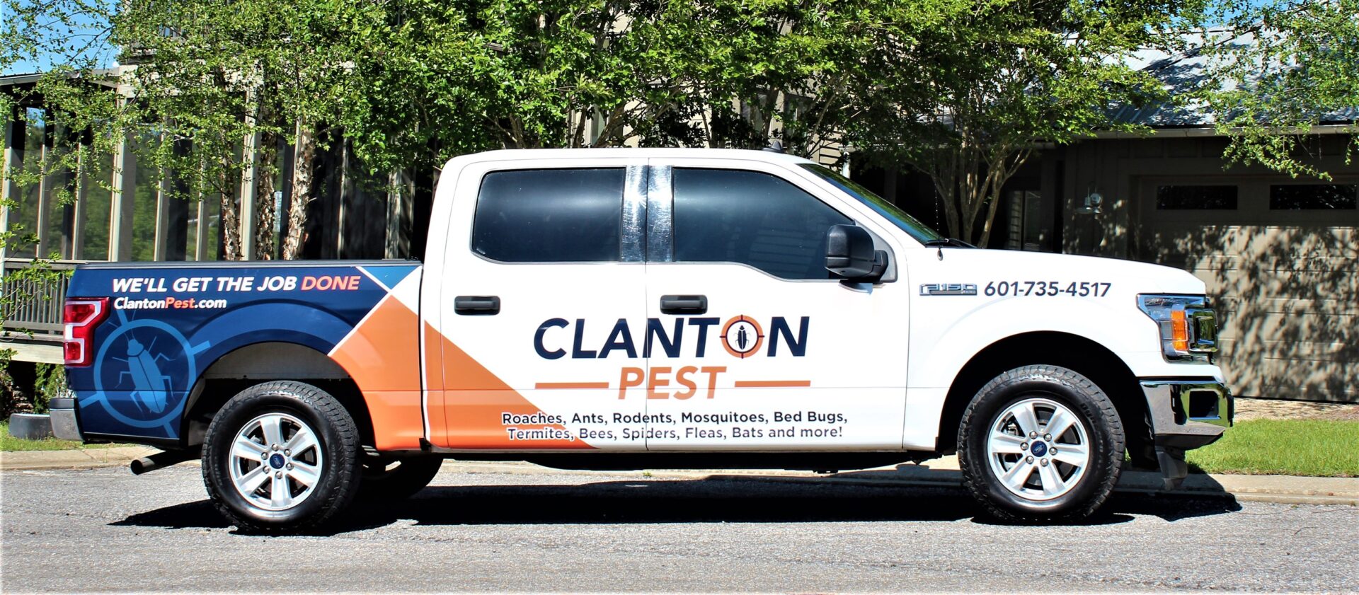 A white truck with orange and blue stripes on the side.