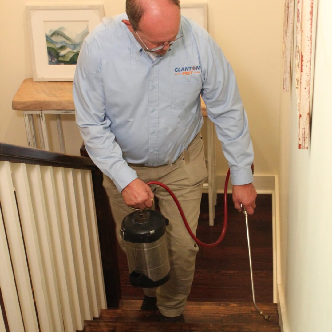 A man is vacuuming the stairs with his vacuum.