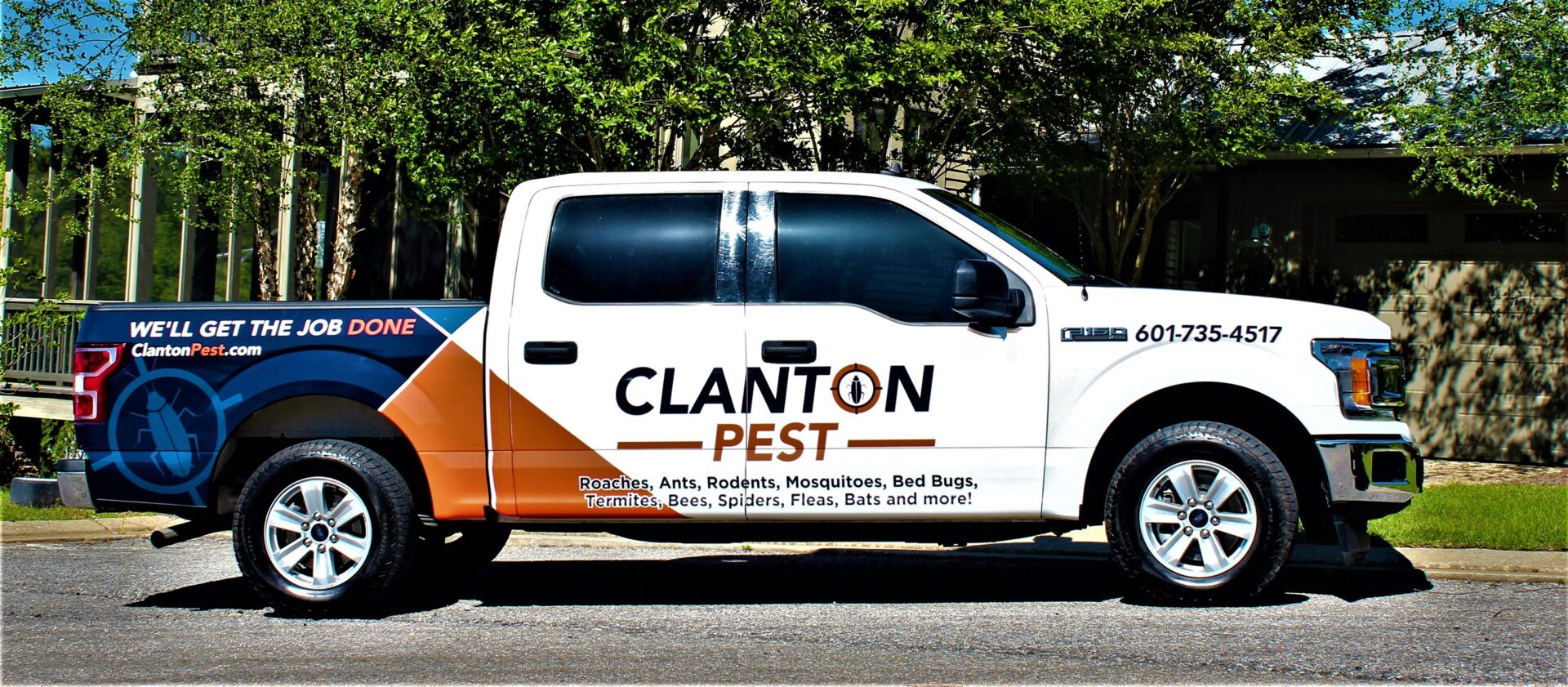 A white truck with orange and blue stripes on the side.